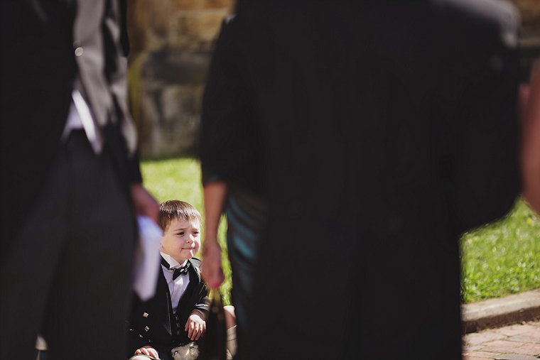 A pageboy sitting quietly looking up at the bride on her wedding day in Tunbridge Wells Kent