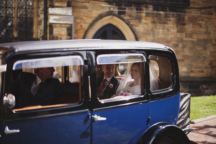 Bride arriving with her father at the church in a vintage car before the start of her wedding at a church in Tunbridge Wells