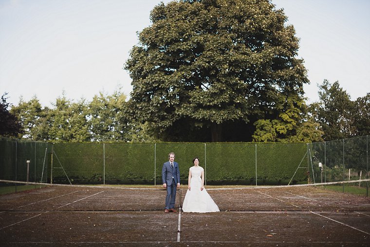 Bride and Groom stood in an old tennis court at Old Kent Barn