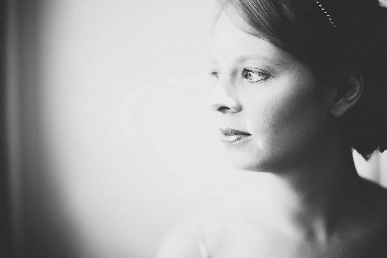 Black and White photograph of a bride in window light