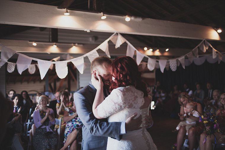 Bride and groom kissing after the end of their wedding ceremony at The Lobster Shack East Quay in Whitstable Kent