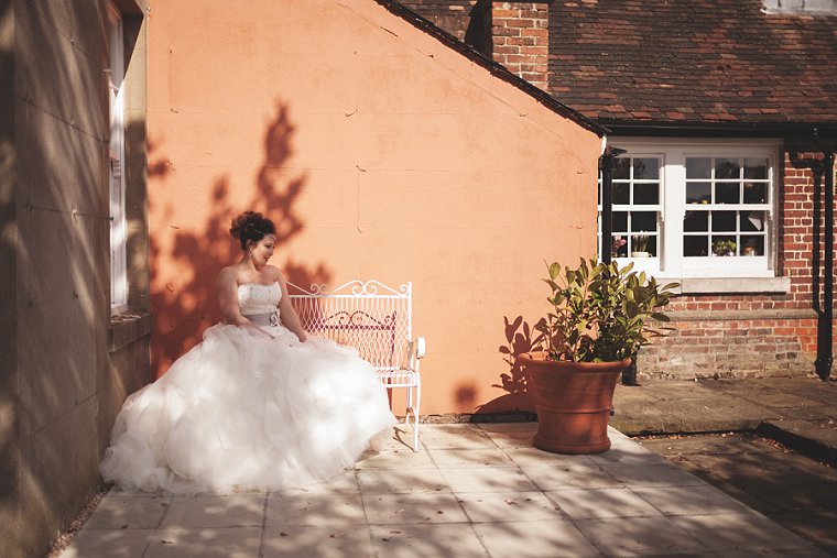 A bride sat on a bench after her wedding. Wedding portrait by Kent Wedding Photographer