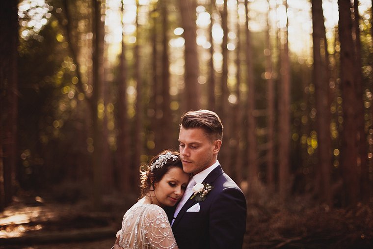 A wedding couple photographed in a forest in Kent hugging