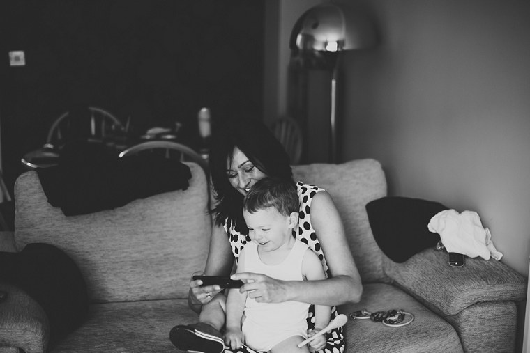 Page boy sitting and playing as he puts on his wedding suit