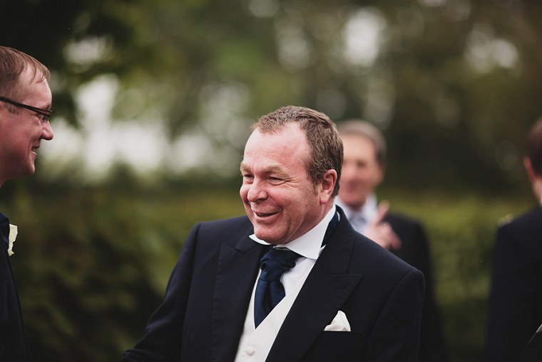 Father of the groom laughing before start of the wedding ceremony