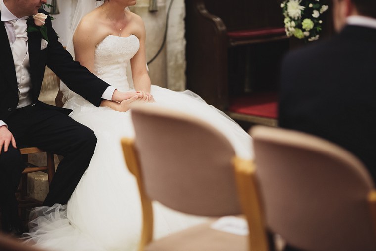 bride and groom holding hands during the wedding ceremony