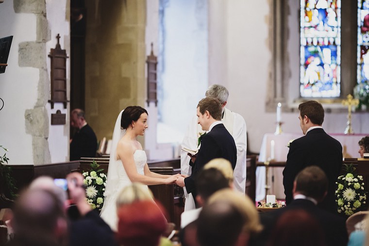 Bride and groom exchanging vows and holding hands