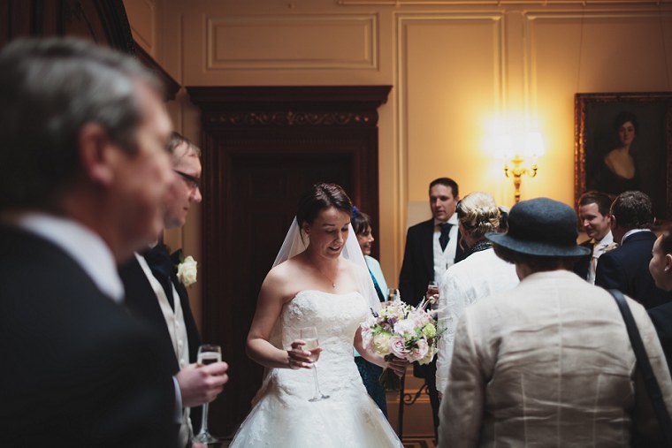 Bride chatting to wedding guests in the main hall at Mount Ephraim in Kent