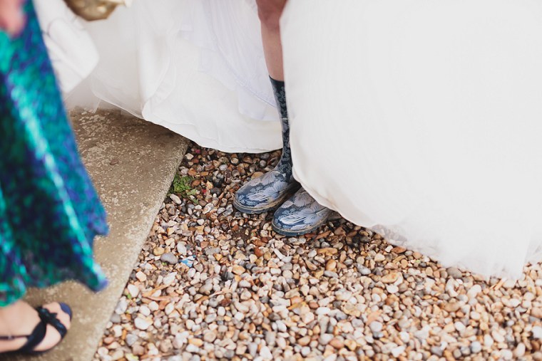 Bride in her wellington boots as she gets ready to have her wedding portraits taken in the gardens of Mount Ephraim