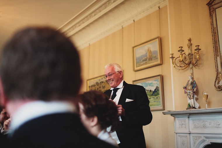 Father of the bride laughing as he gives his speech