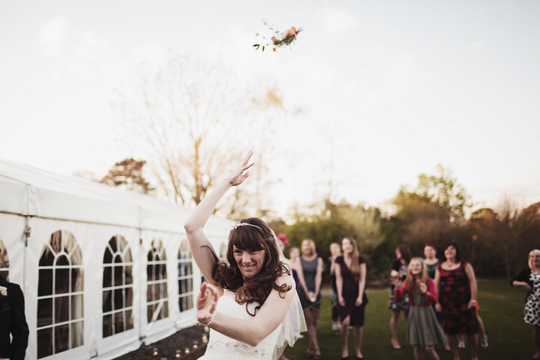 Photo of bride throwing her wedding bouquet at Nettlestead Place